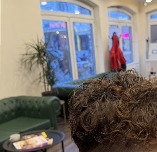 Dauerwelle mit Fade, im Hintergrund Chesterfield-Sofa und Bogenfenster