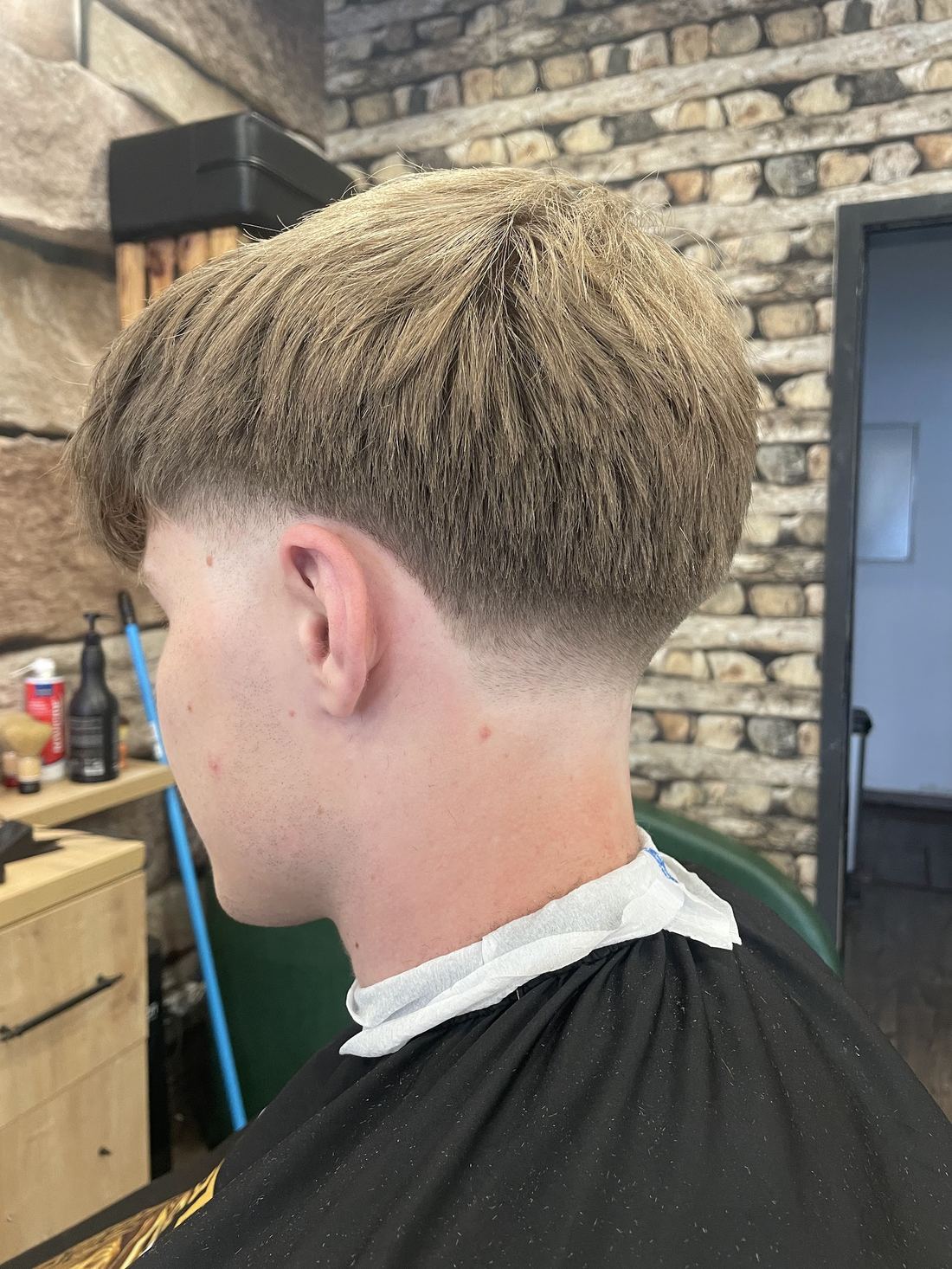 Mittellanger Schnitt mit tiefem Fade, blond